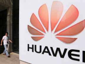 A man walks past a Huawei company logo outside the entrance of a Huawei office in Wuhan, Hubei province Oct. 9, 2012. REUTERS/Stringer