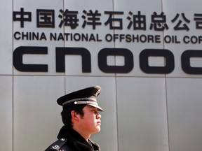 A security officer keeps watch outside the Beijing headquarters of China National Offshore Oil Corp (CNOOC), China's top offshore oil producer