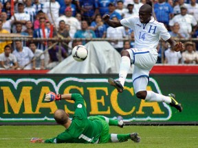 Honduras' Oscar Garcia jumps over Canadian 'keeper Lars Hirschfield to score one of his team's eight goals on Tuesday. (Reuters)