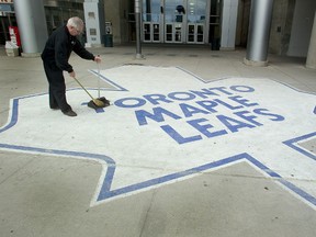 Romiro Coelho, cleans the sidewalk outside the ACC in this file photo. (QMI Agency/DAVID LUCAS)