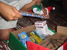 A Costa Rican boy opens his shoebox gift from Operation Christmas Child to find school supplies, toys and Band-Aids. (Clarise Klassen/Portage Daily Graphic/QMI Agency)