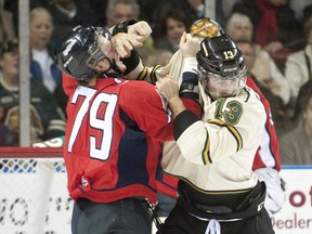 Windsor Spitfires winger Ty Bilcke, left, and London Knights winger Adam Restoule, right, drop the gloves and trade punches early in the first period of their OHL hockey game at Budweiser Gardens in London on Friday October 5, 2012. (CRAIG GLOVER/QMI Agency)