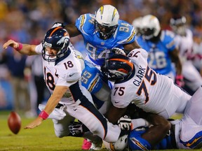Broncos quarterback Peyton Manning (18) is brought down by Chargers linebacker Shaun Phillips (95) and defensive end Corey Liuget (94) during their game in San Diego on Monday, Oct. 15, 2012. (Mike Blake/Reuters)