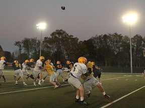 Queen’s University football players run special teams drills during an evening practice in 2012. (Michael Lea/The Whig-Standard)