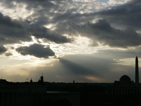 The sun begins to set behind heavy cloud cover as seen from the roof of the Canadian embassy in Washington. (REUTERS FILE)