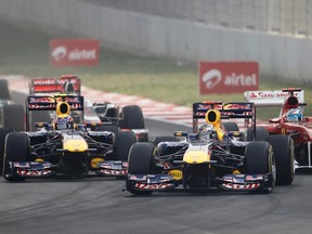Sebastian Vettel of Germany (centre) leads Red Bull teammate Mark Webber of Australia (left) and Ferrari driver Fernando Alonso of Spain at the start of the Indian Grand Prix yesterday. Vettel went on to win the inaugural event, with Alonso second. (REUTERS)