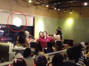A plate is seen mid-air during a fight at the Pho Xe Lua eatery in Chinatown over the weekend. (YouTube screengrab)