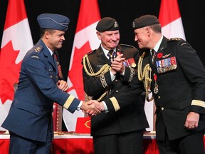 Outgoing CDS General Walt Natynczyk (R) shakes hands with the new CDS RCAF General Tom Lawson(L) with David Johnston, Governor General of Canada,  during the Chief of Defence Staff Change of Command ceremony at the Canadian War Museum  in Ottawa Oct 29, 2012. (ANDRE FORGET/QMI AGENCY)