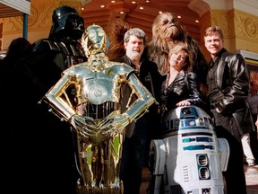 Director and writer of Star Wars, George Lucas poses with cast members Carrie Fisher and Mark Hamill along with characters Darth Vader, C3PO, R2D2 and Chewbacca during the premiere of Star Wars Special Edition in this January 18, 1997 file photo. Walt Disney Co agreed to buy filmmaker George Lucas's Lucasfilm Ltd and its Star Wars franchise for $4.05 billion in cash and stock, a blockbuster deal that includes the surprise promise of a new film in the series in 2015, Reuters reported on October 31, 2012. (REUTERS/Fred Prouser)