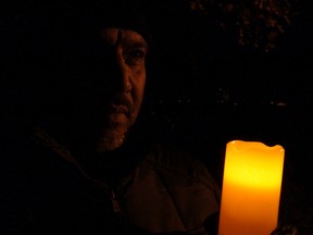 Rashed Salman is shrouded in darkness at a candlelight vigil for missing people Wednesday night at Remic Rapids. Salman's son Abdullatif has been missing since Oct. 24, 2010. (TONY SPEARS/Ottawa Sun)