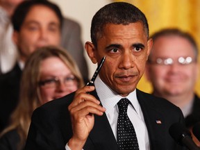 U.S. President Barack Obama holds up a pen as he delivers a statement on the U.S. "Fiscal Cliff" in the East Room of the White House in Washington, November 9, 2012. REUTERS/Kevin Lamarque