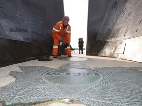 A war memorial in Coronation Park was vandalized with black spray paint. City worker Margaret O'Brien sprays the words "Canada will burn praise Allah" with a chemical to remove them. (CRAIG ROBERTSON/Toronto Sun)