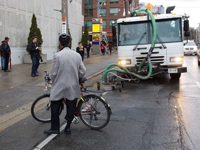 Protester Chris Drew blocks a special truck trying to blast away the bike lane paint on Jarvis St., Monday Nov 12, 2012. (MICHAEL PEAKE/Toronto Sun)