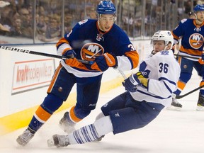 Toronto Maple Leafs Carl Gunnarsson (R) is tripped up by New York Islanders Travis Hamonic in the third period of their NHL hockey game in Toronto January 23, 2012.  (REUTERS)