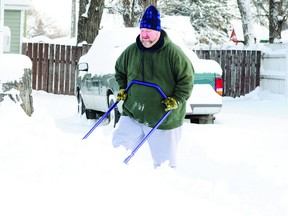 Brent Bobei clears snow out of his driveway on Sunday in Portage la Prairie.  City crews continue to make their rounds as they hope to fully complete snow removal on Tuesday.  (Jordan Maxwell/Portage Daily Graphic/QMI Agency)