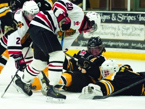 Smiths Falls goalie Jimmy Howe covers the puck as Braves forward Erik Brown jams aways at it during Brockville's 7-1 loss to the Bears on Tuesday night (Photo courtesy Jason Code).