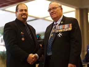 Darrell Krushelnicki receives the bronze medal for bravery from Lt. Gov. Donald S. Ethell during the Royal Canadian Humane Association awards presentation at Edmonton Police Service headquarters in Edmonton on Monday, November 12, 2012. Krushelnicki purposely drove his vehicle into the path of a speeding motorist in order to save three teenagers and a young child from being struck. CODIE MCLACHLAN/QMI AGENCY