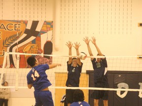 A pair of St. Martin de Porres Kodiaks stuff a James Fowler attack during the third set of the Kodiaks’ 25-11, 25-12, 25-11 first round playoff victory in the St. Martin gym on Tuesday night.