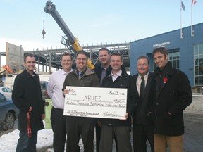 From left, James Emery, Keith Wilkinson, Rob Jamieson, Greg Lockert, Trent Olson, Airdrie Mayor Peter Brown and Crossfield Mayor Nathan Anderson pose with a cheque for $19,699 raised at the 2012 Winter Challenge hockey game for the two new rinks at Genesis Place.