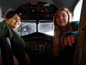 Melody Neveau, 18, and Nicole Woolsley, 17, sit in the cockpit of an airplane at the Canadian Bushplane Heritage Centre on Wednesday.