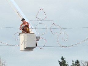 Andy Redmond of Redmond’s Tree Service installs a section of the replica Noma lights display in 2nd Ave. E. in Owen Sound Tuesday afternoon in preparation for the Festival of Northern Lights, which opens Friday night. James Masters The Sun Times