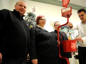 Adam Jackson/Daily Herald-Tribune
Mayor Bill Given, right, makes the first donation to officially kick off the Salvation Army’s Christmas kettle campaign Wednesday at the Family Service Centre on 102 Street. He is joined by co-ordinator Kerry Harris, left, Major Glenda Roode, and Major Daniel Roode.