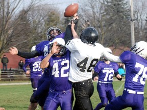 Warren McAllister of Huron Park deflects a pass during the third quarter of WEdnesday afternoon's southeast varisty 'B' championship as Josh Hadjinovic (No. 42) and Wyatt Onyczyszyn block Holy Cross' Jamieson Howes from making a play. Huron Park won 31-22.