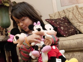 Zoe Medeiros, 7, hugs her Disney plush toys in the living room of her Westmount home in London on Monday October 15, 2012.  Medeiros, who has spastic cerebral palsy, is heading to Walt Disney World with her parents thanks to a trip organized by the Sunshine Foundation, a London-based charity that grants dreams to children with physical disabilities and life-threatening illnesses. (CRAIG GLOVER, The London Free Press)