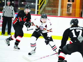 Brockville Tikis forward Cody Waite attempts to stickhandle between a pair of Gananoque Islanders, including Logan Purbrick (17), during Wednesday's night's game, won 4-3 by Gananoque (STEVE PETTIBONE THE RECORDER AND TIMES).