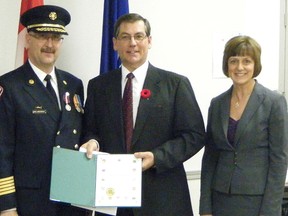 Cochrane Fire Chief Mac deBeaudrap was presented the Queen's Diamond Jubilee Medal by Crowfoot MP Kevin Sorenson, accompanied by his wife Darlene.