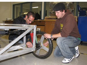 Lambton College students Sean Seys and Justin Plaxton work on the college's solar-powered car Monday. Alternative energy students are now starting fundraising efforts as they continue to work away at their entry for the 2014 American Solar Challenge. BARBARA SIMPSON/THE OBSERVER/QMI AGENCY