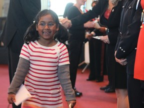 Nawra Roya, 7, is all smiles after receiving her citizenship certificate along with 62 other people Thursday afternoon in Kingston.
Elliot Ferguson The Whig-Standard