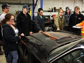 Students from Northern College's mechanical apprenticeship program listen attentively as Ministry of Transportation of Ontario (MTO) officer Brian Maguire, right, gives tips on how to inspect a vehicle for defects and safety flaws. The OPP and MTO spearheaded the program to get unfit vehicles either repaired or off the street.