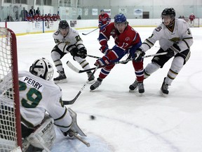 Kingston Voyageurs’ Brandon O’Quinn looks for the puck in front of Cobourg Cougars goalie Nathan Perry as he gets hooked by Cougars Connor Armour (22) and Riley Robertson (3) during Ontario Junior Hockey League action at the Invista Centre on Thursday night. (Ian MacAlpine/The Whig-Standard)