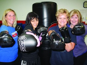 Kickboxers (l-r) Kristie Timmins, Katherine Coles, Lori Cox and Cathy Hudson show off their kickboxing moves at Shaku Family Martial Arts. The four women say the sport has not only increased their self-confidence, but improved their physical health as well.