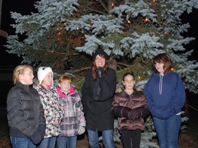 Faith Lamb, left, Karrissa Page, Maggie Ray sing Chrismtas carols with Stephanie McIlroy and her daughter Hannah McIlroy Friday in Dutton at the Christmas tree light up. On the right is Geneva Brown.