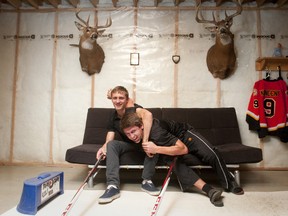 Chase Konecny, left, and his brother Travis have claimed part of their basement as a practice space for hockey. Turns out brotherly love is helping 15-year-old Travis pursue his dreams of stardom. (CRAIG GLOVER, The London Free Press)