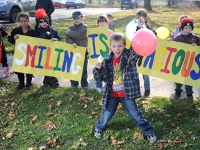 Tristan Horner, 6, spreads some smiles as part of a class project to show the world that 'Smiiling is Conatagious.' Horner and his Grade 1 class at Hannah Memorial Public School took their message to the corner of Maria and Russell streets Friday, encouraging passersby to smile and honk. DANIEL PUNCH/ THE OBSERVER/ QMI AGENCY