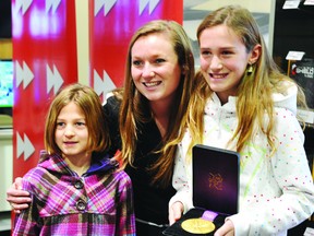 2012 Olympic trampoline gold medalist Rosie MacLennan poses with sisters Sydney Eyre (holding medal) and Charlotte Eyre during an appearance Friday in Brockville. STEVE PETTIBONE/The Recorder and Times