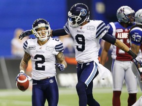 Argos' Chad Owens (left) is congratulated by teammate Maurice Mann after a long catch and run against the Alouettes in Sunday's East final in Montreal. Owens finished with 207 yards receiving and a combined 139 return yards.