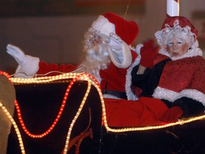 Santa and Mrs. Claus wave from their sleigh pulled by the reindeer at the end of the annual Santa Claus parade Saturday night, Nov. 17, in Woodstock. Hundreds turned out to see the decorated floats, marching bands and the jolly old man himself.