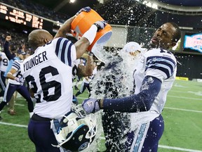 Argonauts' Jordan Younger (left) pours water on head coach Scott Milanovich with teammate Dontrelle Inman (right) after their team defeated the Alouettes in the East final on Sunday. (REUTERS)