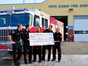 Grande Prairie firefighter calendar committee Landon Daigneault (left), Mike Cooke, Jordan Wuttunee, Torren Freeman and Steph Garand proudly hold a $30,000 cheque in front of the Pete Eagar Fire Hall on Friday. GPFD firefighters were able to raise the money through its 2013 Firefighter Calendar. (Aaron Hinks/Daily Herald-Tribune)
