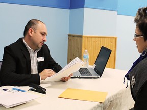 Applicant Elisa Kuuru-Goodman hands her application to John Crescenzi during Saturday's Holiday Inn job fair at Centre Cultural La Ronde Saturday. Thirty jobs are currently available at the hotel and staff expansion is planned over the next few months.