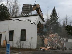 A backhoe tears into the garage portion of the old mine rescue building in Schumacher Monday morning. Goldcorp Porcupine Gold Mines announced last week that it was going to demolish the building after determining it was no longer safe for public use.