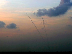 Smoke trails are seen as two rockets are launched from the central Gaza Strip towards Israel November 19, 2012. REUTERS/Yannis Behrakis