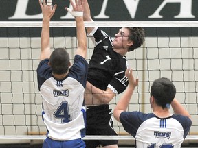 St. Joseph Celtic Brock Penson smashes into the defending of Peace Wapiti Titan Dylan Smith. The Tier III northwest zone volleyball playoffs concluded Friday at St. Joseph high school. St. Joseph Celtics won the boys’ tournament while the Beaverlodge Royals won the girls’ tourney. (Terry Farrell/Daily Herald-Tribune)