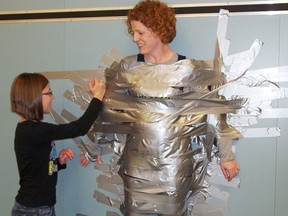Jessica Barkley, 11, helps tape teacher Tricia MacDonell to a wall at Rothwell Osnabruck Elementary and Secondary School after Barkley cut some of her hair off as part of a cancer awareness fundraising effort. The elementary students raised more than $400 for the Canadian Cancer Society.
Erika Glasberg staff photo