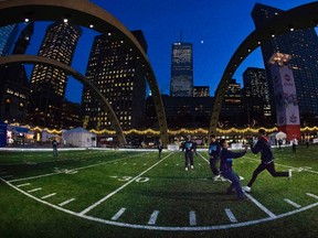 People play football on a gridiron field that was temporarily installed in downtown Toronto, November 19, 2012. The field was installed at Nathan Phillips Square to celebrate the CFL’s 100th Grey Cup championship game being played on Sunday in Toronto. (MARK BLINCH/Reuters)