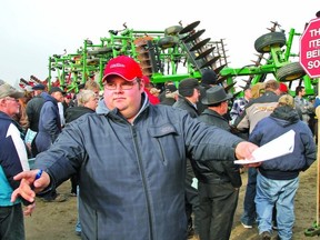 MIKE BEITZ The Beacon Herald
Thousands of people turned out Monday morning for the massive farm equipment auction at Hahn Farms Ltd. just outside of Stratford. Here, Dave Jacob helps to relay bids from the crowd to the auctioneer calling out the offers on a loudspeaker.